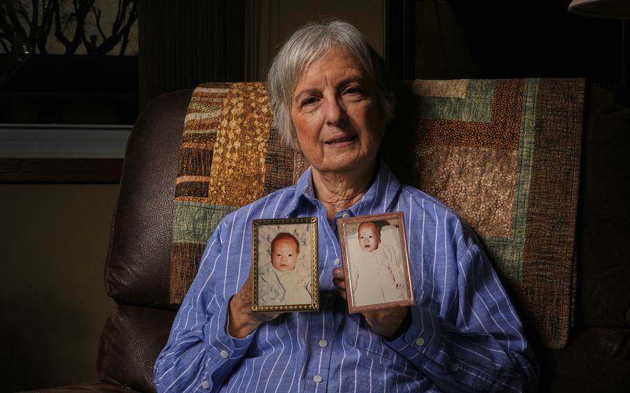 A lady holds photos of babies at her home in Wisconsin.