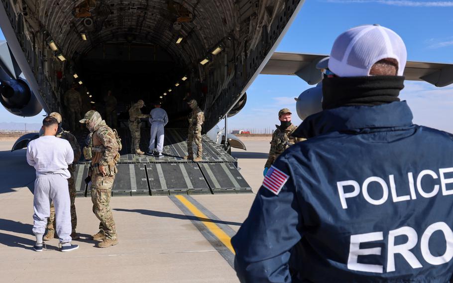 Men stand near an airplane in the U.S.