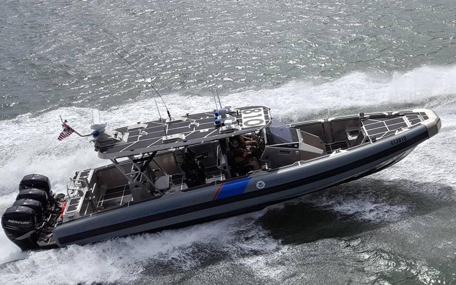 A U.S. federal boat speeds through the water.