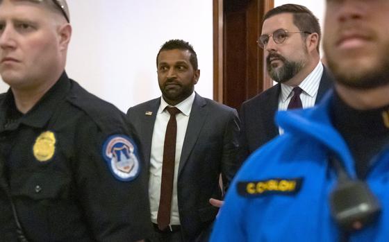 A government official with other men walk through a building.