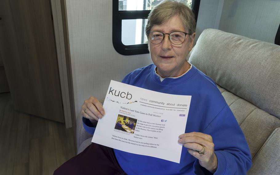 Mary Nelson, of Mead, Wash., poses for a photo at her home on Wednesday, Oct. 2, 2024. Nelson is holding a printout of a radio station website news story that says she is thought to be the last person in the U.S. to cast a vote in the 2012 presidential election when she voted for Mitt Romney just before the polls closed in the remote village of Adak, Alaska. 