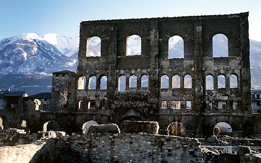 Part of the facade of Aosta’s Roman theater towers above the ruins of an amphitheater, which once offered covered seating for spectators in the first century B.C.