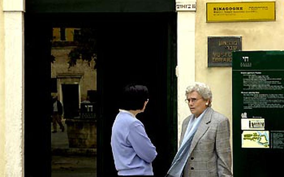 Two women have a conversation in front of the Jewish museum in Venice, which is also an active synagogue.