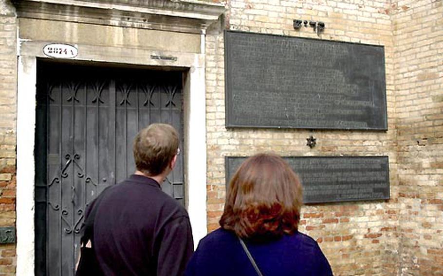 Tourists read a plaque on a wall of the Venice Ghetto remembering the Holocaust and the arrest and deportation of Venice Jews on Dec.5, 1943, and Aug. 17, 1944.