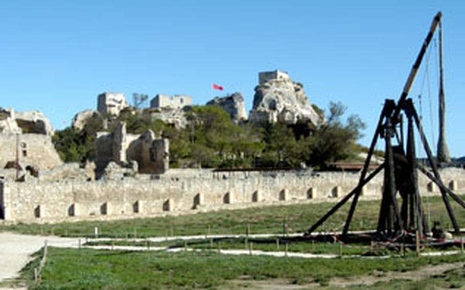 This model of a catapult stands on the plateau of the Les Baux citadel. A similar one was once used in midieval times to attack the castle. At left is the 12th-century Chapelle St-Blaise, at center is the citadel, and at far right another catapult.