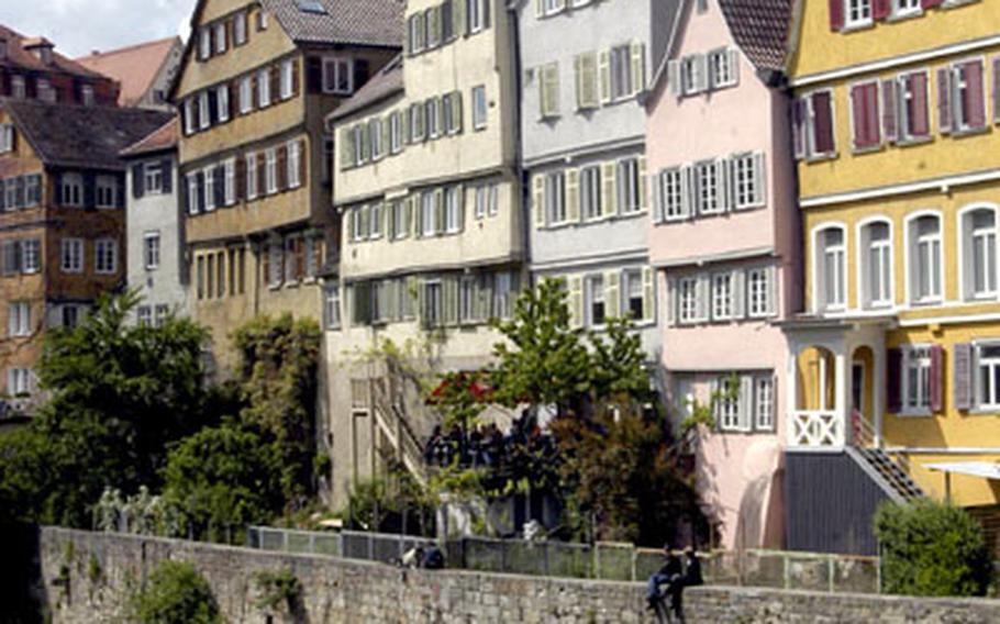 Historic buildings overlook the Neckar River in historic Tübingen. In the background is the steeple of the 15th-century Stiftskirche.