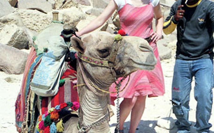 British tourist Anya Clark, who rode with Stars and Stripes reporter Ben Murray to the back of the Great Pyramid of Khafre, stands with “Sam,” the Giza guide, and Moses 2000, the trusty camel, just after climbing down from the side of the monument.