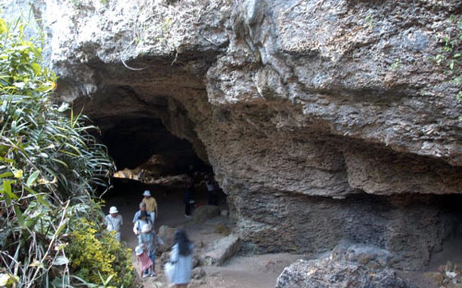 Visitors peak into the Niya-thiya cave during a stop on the Ie Shima bus tour. The cave was used a bomb shelter during World War II. Inside sits a rock monument — legend says that if a woman lifts the rock, she will become pregnant soon after.