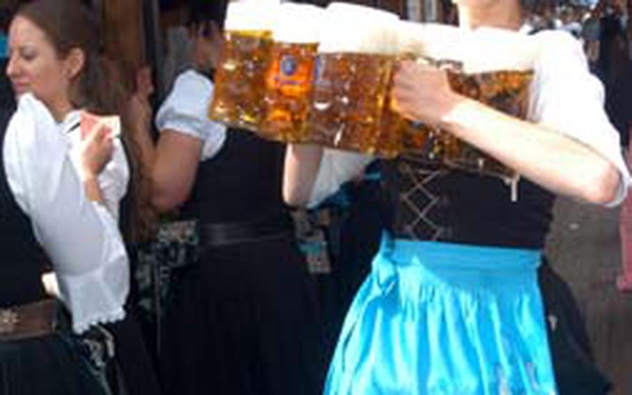 A server rushes with several liters of beer to thirsty customers at the Löwenbräu tent. One liter of beer costs about 8.60 euros.