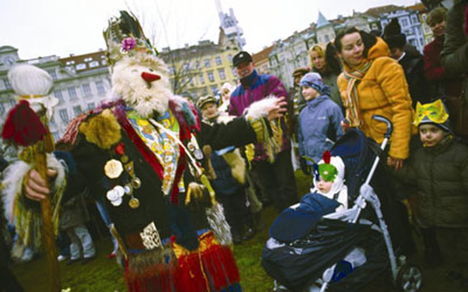 A costumed marcher greets spectators at the end of the Masopust parade in Zizkov. The district has taken the lead in reintroducing carnival traditions that disappeared from big cities during communist rule.