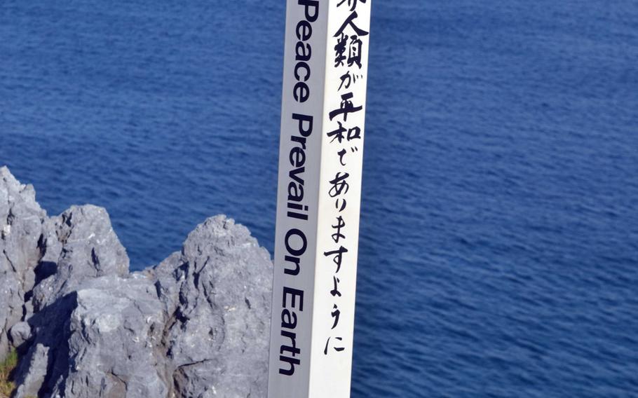 A plea for peace on Earth, in English and Japanese, on a white pole at Cape Hedo park.